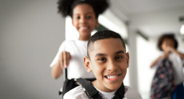menino negro em cadeira de rodas na escola