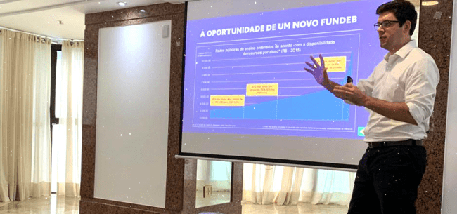 Olavo Nogueira Filho fala ao lado de telão sobre oportunidade de um novo fundeb