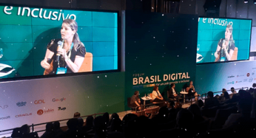 Fórum Brasil Digital vista de cima de auditório com dois telões projetando priscila cruz ao microfone