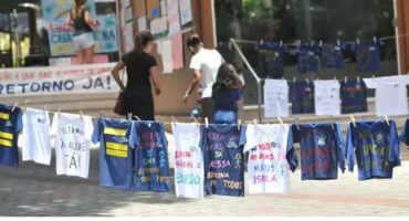 camisetas penduradas em varal em protesto em frente de escola