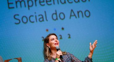 Priscila Cruz é Mulher Loira em pé em cima do palco do Prêmio Empreendedor Social 2022