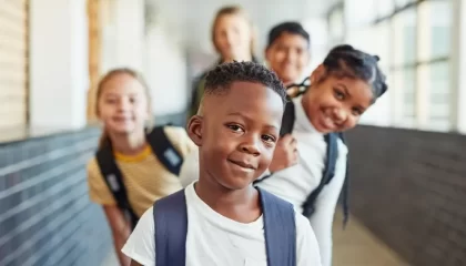 menino negro no primeiro plano com 4 crianças atrás dele em fila