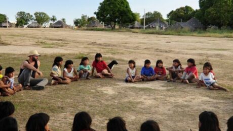 crianças indigenas senatadas no chão da aldeia