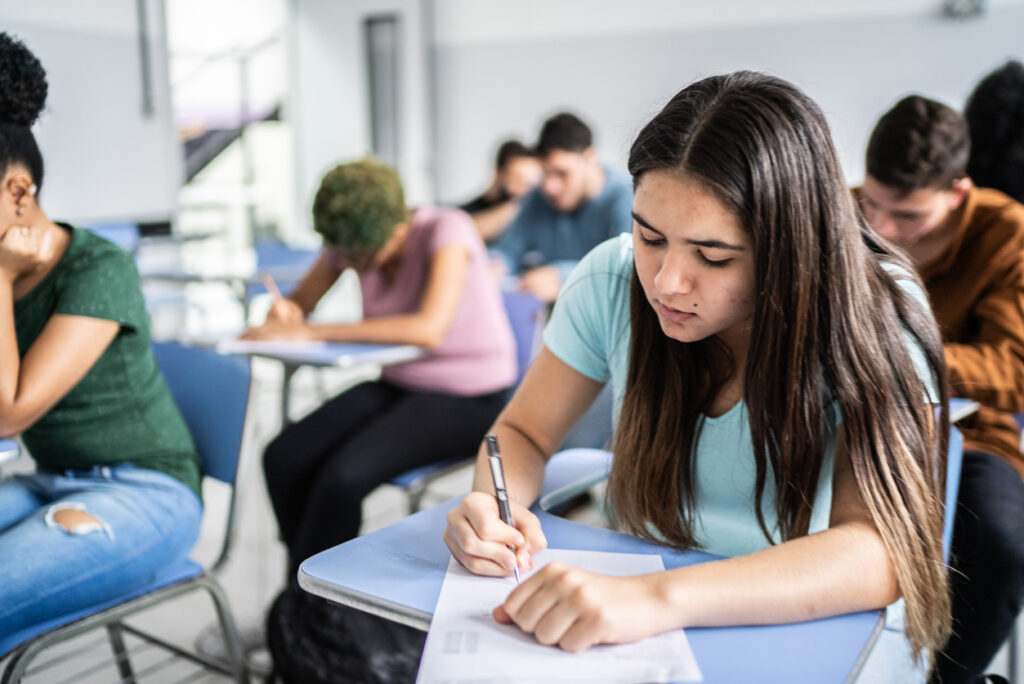 jovens concentrados, fazendo prova sobre suas carteiras